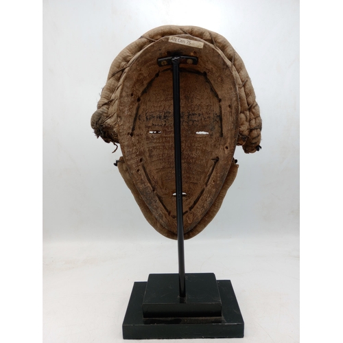 2143 - Vintage African Dan, Hand carved wooden Mask, displayed on heavy black Metal stand, H40cm