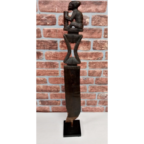 2146 - Vintage African hand carved wooden ceremonial dagger, displayed on heavy black metal stand, H114cm