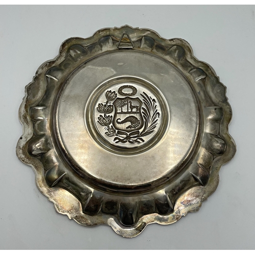 165 - Peruvian silver salver, centrally embossed with a shield crest, 23cm diameter, 9.5oz approx