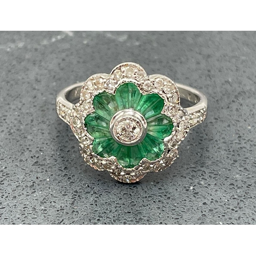 61 - Well made 18ct white gold, emerald and diamond flower ring, central .10ct stone, size N, 3.6g