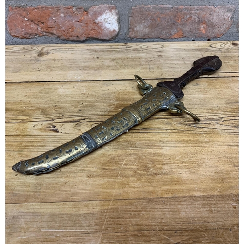 75 - 19th century Jambiya dagger with iron blade and carved wooden hilt, held in a decorative scrolled br... 