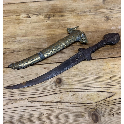 75 - 19th century Jambiya dagger with iron blade and carved wooden hilt, held in a decorative scrolled br... 