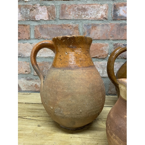 123 - Four antique 18th Somerset glazed earthenware pitcher jugs with additional glazed puzzle jug example... 