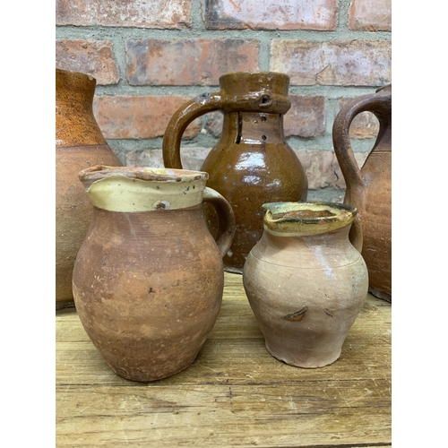 123 - Four antique 18th Somerset glazed earthenware pitcher jugs with additional glazed puzzle jug example... 