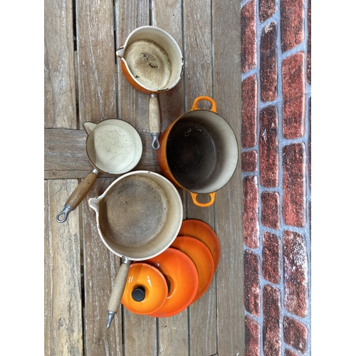 20 - Quantity of volcanic orange Le Creuset kitchenware to include saucepans and casserole dish