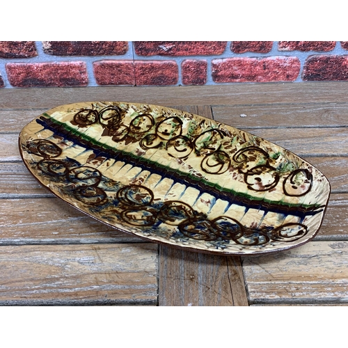 645 - Impressive studio pottery slipware dish with central spine design and abstract circle surround, L 59... 