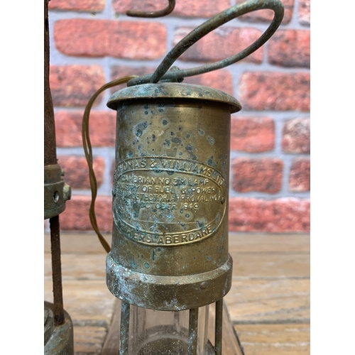 655 - Two vintage brass and tin Welsh miners lamps by Thomas and Williams Ltd, 27cm and 20cm respectively ... 