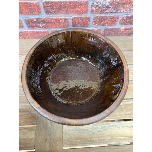 465 - Two graduated French antique treacle glazed terracotta dairy bowls, largest H 15cm x D 47cm