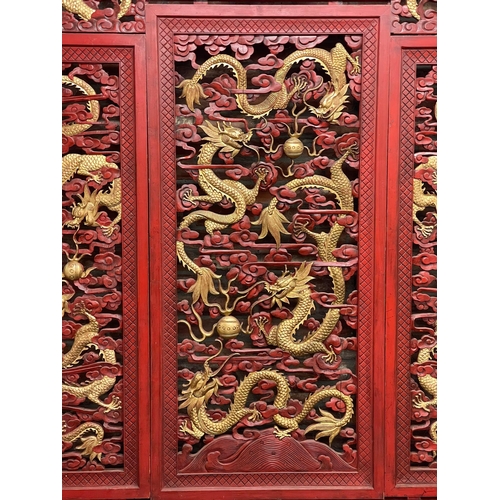 1240 - Large ornate Chinese cinnabar type red lacquered screen, pierced with gilt pearl chasing dragons, L ... 