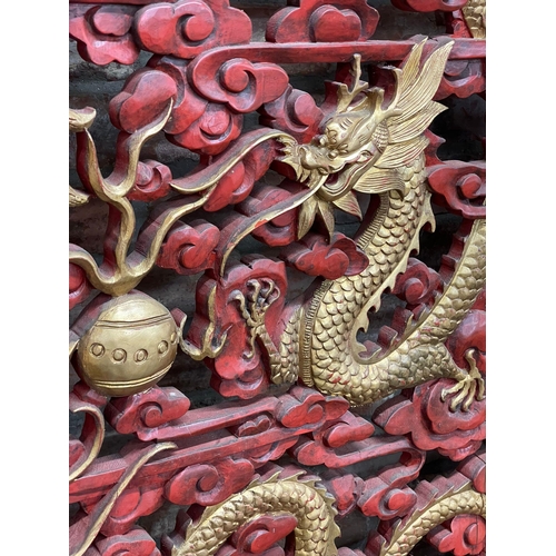 1240 - Large ornate Chinese cinnabar type red lacquered screen, pierced with gilt pearl chasing dragons, L ... 