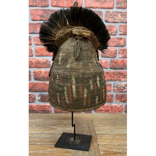 390 - Papua New Guinea helmet mask, pigment and feather decoration, atop metal stand, H 68cm