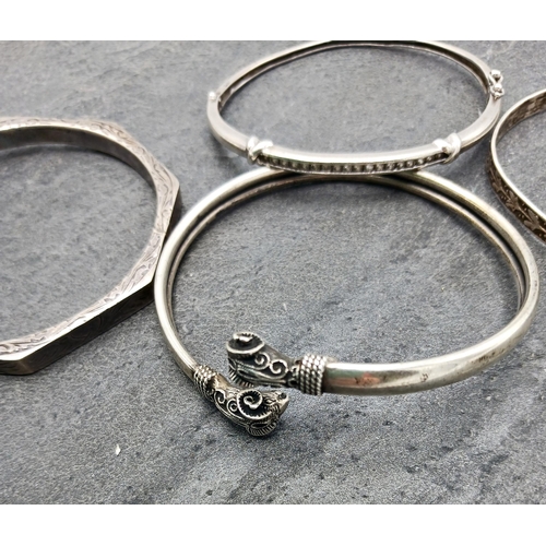 130 - Four silver bangles, two being hinged another with rams head details, 43.2g