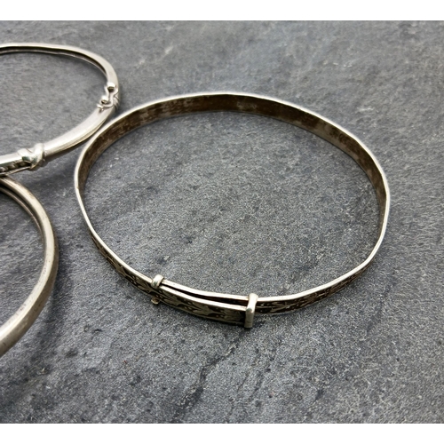 130 - Four silver bangles, two being hinged another with rams head details, 43.2g