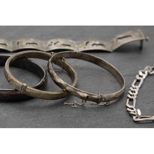 137 - Three antique silver hinged bangles with a further Spanish silver bracelet with enamel hinged panels... 