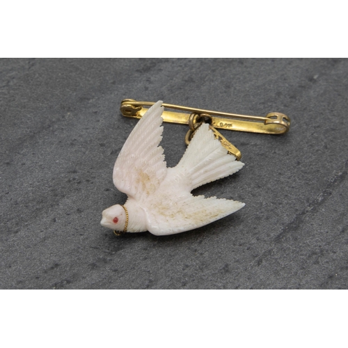 138 - Unusual 9ct bar brooch with carved white coral dove with gem set eye, 6cm high in total