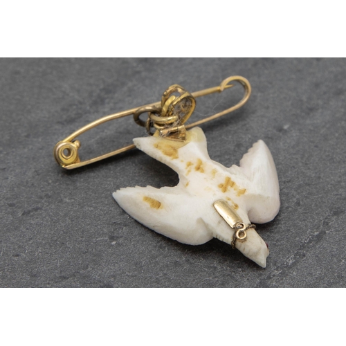 138 - Unusual 9ct bar brooch with carved white coral dove with gem set eye, 6cm high in total