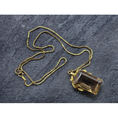 73 - Yellow metal and smoky quartz pendant, the bale marked 14k, on a 9ct chain, chain 62cm, 20.8g