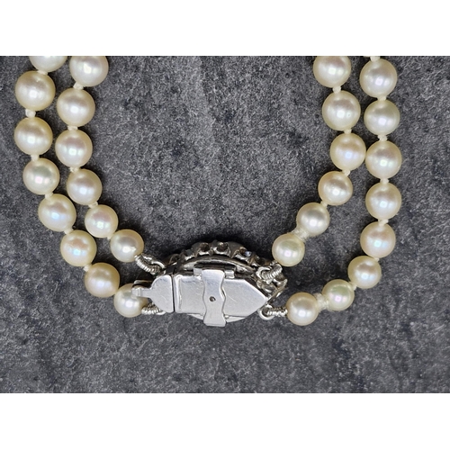 77 - Mid 20th century graduated double row pearl necklace with good diamond and platinum clasp, the clasp... 