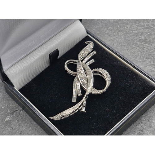 81 - Impressive 14k white gold and diamond ribbon brooch, set with multiple rose and baguette cut stones,... 