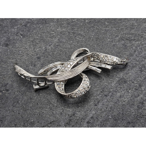 81 - Impressive 14k white gold and diamond ribbon brooch, set with multiple rose and baguette cut stones,... 