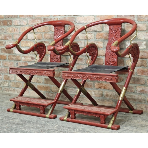 1249 - Pair of 20th century Chinese folding red lacquered horseshoe chairs with applied brass mounts and ca... 