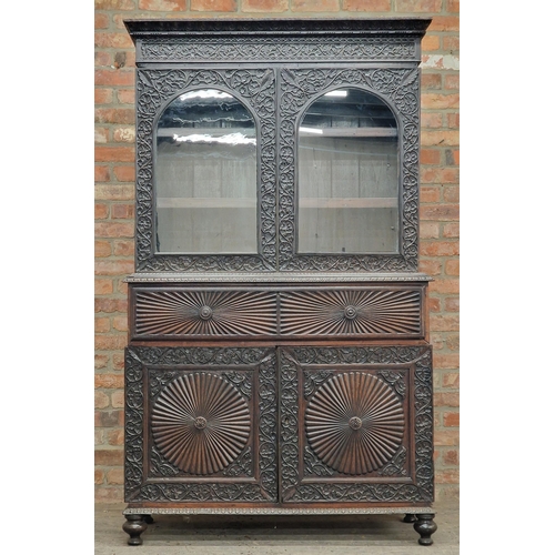 1292 - Anglo Indian hard wood two sectional bookcase with profusely carved floral decoration and twin glaze... 