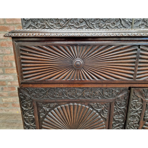 1292 - Anglo Indian hard wood two sectional bookcase with profusely carved floral decoration and twin glaze... 