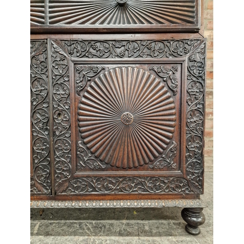 1292 - Anglo Indian hard wood two sectional bookcase with profusely carved floral decoration and twin glaze... 