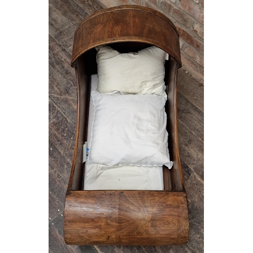 1304 - Antique oak rocking cradle complete with bedding, H 60cm x W 93cm x D 51cm