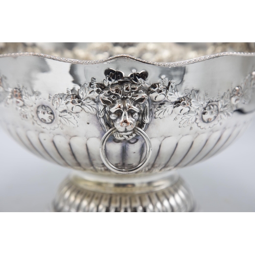 156 - Large silver plate punch bowl with lion head handles and repoussé foliage, raised atop circular foot... 