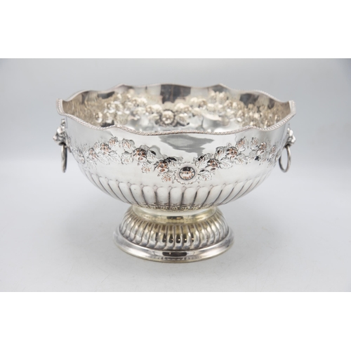 156 - Large silver plate punch bowl with lion head handles and repoussé foliage, raised atop circular foot... 