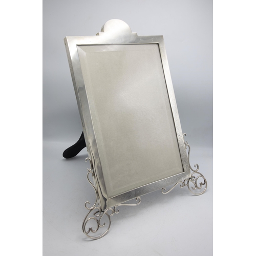 198 - Large and impressive Victorian silver easel picture frame, with scrolled front feet and bevelled gla... 