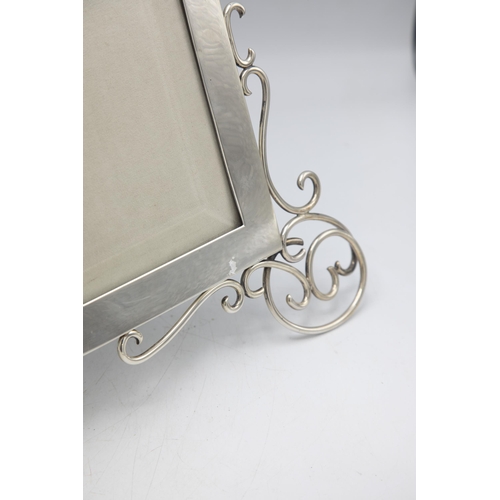 198 - Large and impressive Victorian silver easel picture frame, with scrolled front feet and bevelled gla... 