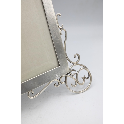 198 - Large and impressive Victorian silver easel picture frame, with scrolled front feet and bevelled gla... 