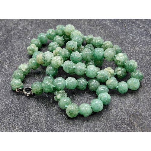 129 - Carved jade bead necklace, hand knotted, 55cm long with a further jade and amber type bead necklace ... 