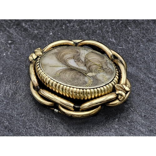 146 - Victorian pinchbeck swivel mourning brooch, fitted with a fan of hair, 5.5 x 4.5cm, 27.6g