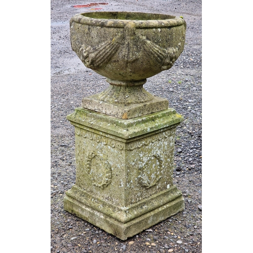 1020 - Weathered reconstituted stone garden urn with swag relief raised on a square pedestal base, H 74cm x... 