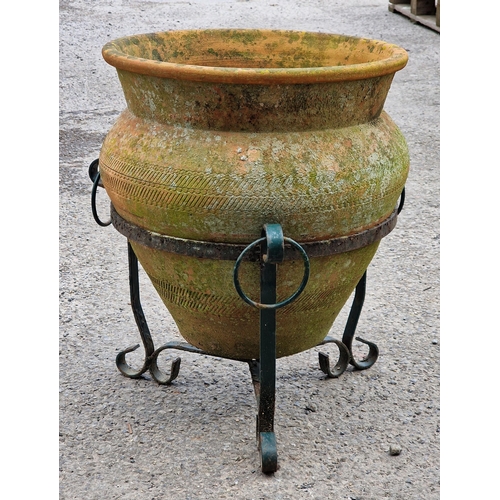 1080 - Good weathered terracotta planter with incised decoration raised on a painted metal scrollwork stand... 