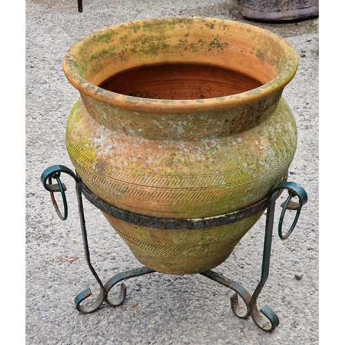 1080 - Good weathered terracotta planter with incised decoration raised on a painted metal scrollwork stand... 