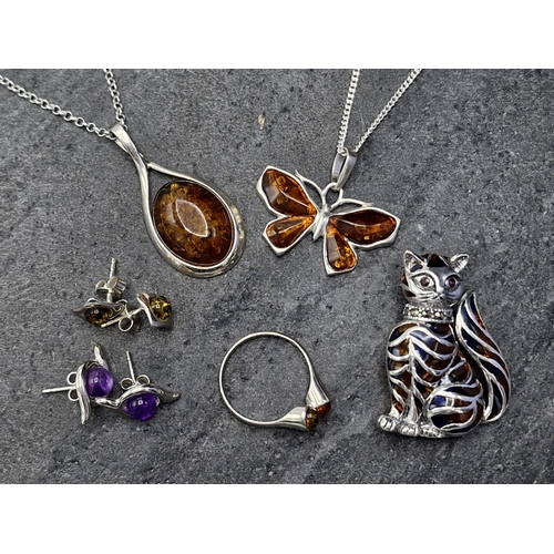 57 - Collection of silver and amber jewellery - pendant and chain, butterfly pendant and chain, cat brooc... 