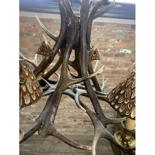 1402 - Impressive stag antler six light chandelier, each shade having pheasant feather decoration, D 110cm ... 