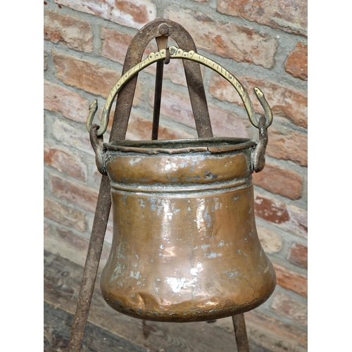 1142 - Antique copper cauldron raised on a wrought iron stand, H 104cm