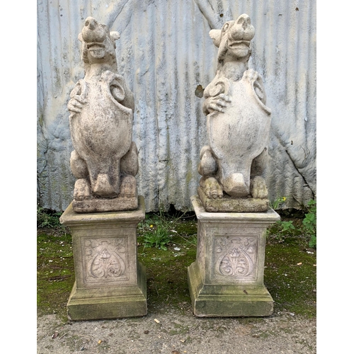 1160 - Pair good quality reconstituted stone Dragons of Griffins holding shields upon well moulded plinth b... 