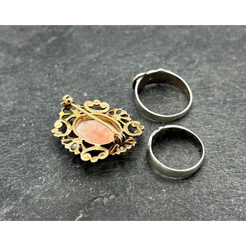 56 - Two silver buckle rings, with inset red gem, Size R and L respectively, with a silver gilt and pearl... 