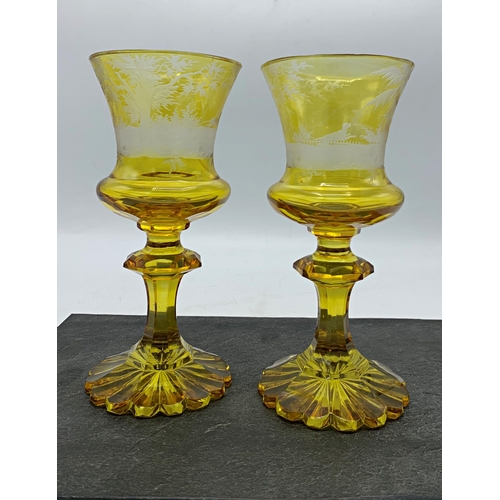 489 - Good quality pair of Bohemian amber glass goblet, etched with a stag hunting scene, 17.5cm high (2)