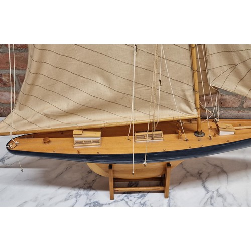 1588 - Large handmade wooden yacht on stand, having hand painted blue hull and cloth sails, L 120cm x H 120... 