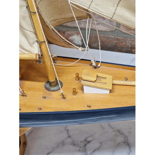 1588 - Large handmade wooden yacht on stand, having hand painted blue hull and cloth sails, L 120cm x H 120... 