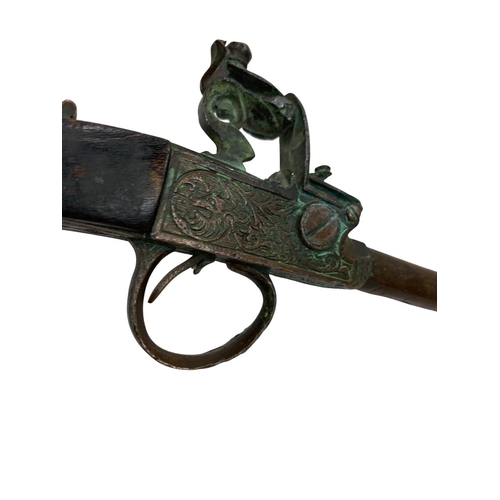 225 - 19th century flintlock pistol, having wooden handle and ornate acanthus leaf decoration to action, s... 