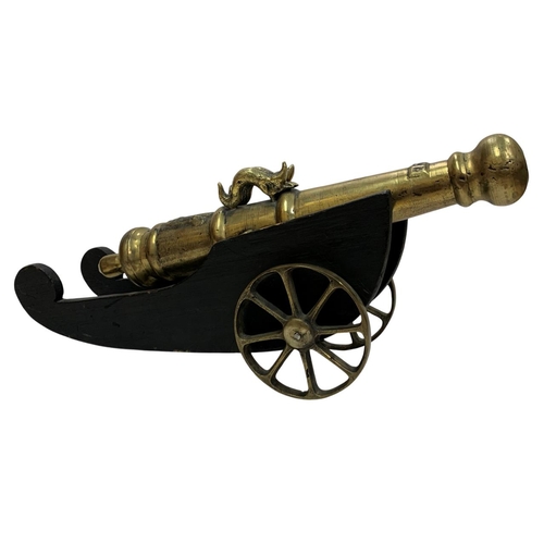 222 - Two brass desktop cannons atop carved wooden carriages, each having the breech of the cannon tube ad... 