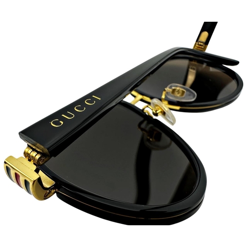 167 - A pair of Gucci Sunglasses for men with black and gold frame and brown lenses. Model number GG0447S.... 